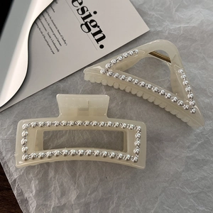 Detailed view of pearl and rhinestone hair claws in rectangle and triangle shapes
