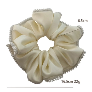 Elegant cream satin hair scrunchie with pearl trim detailing for versatile ponytail styling
