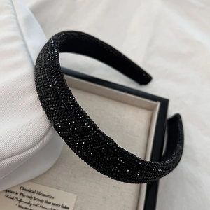 Détail macro du serre-tête rembourré avec strass noirs sur tissu en soie blanc