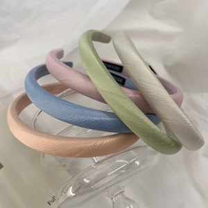 Five macaron colored fabric headbands in a stacked display with handmade labels