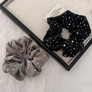 Detailed macro view of black and gray velvet hair scrunchies with sparkling rhinestones