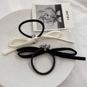 Elegant bow hair ties set with metallic floral accents on textured satin ribbons