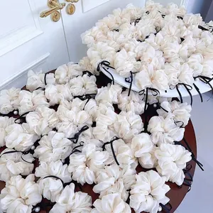 Eleganti elastici in organza crema con fiocchi di nastro nero e perle bianche