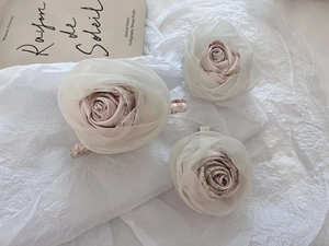 Detailed view of three layered chiffon rose hair claws in pale pink and cream fabric