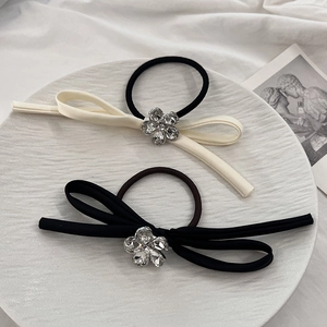 Close-up of bow hair ties with crystal flower center on elegant ceramic plate