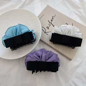 Detail of blue, white and purple fabric bow hair claws with ruffle ribbon accents