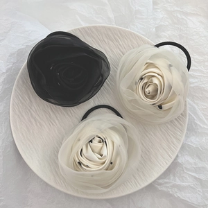 Detail view of handmade chiffon floral hair scrunchies in black and polka dot beige
