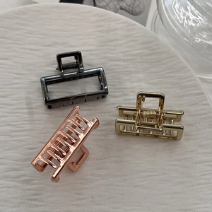 Three minimalist geometric metal hair claw clips in black, gold, and rose gold finishes