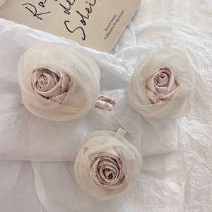 Close-up of pink fabric rose hair clips with delicate organza petals in a 3-piece set