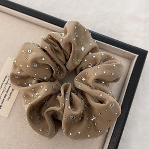 Detailed view of luxury brown velvet scrunchie with sparkling rhinestones decoration