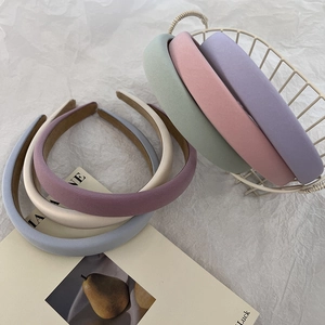 Gros plan sur des serre-têtes épais en éponge macaron aux tons pastel pour coiffure volumineuse