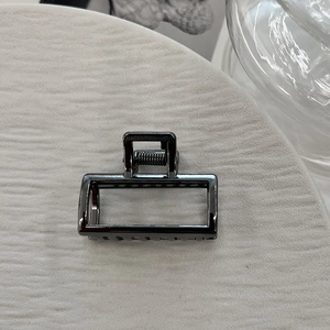 Close-up of small gunmetal rectangle hair claw clip with hollow metal spring design