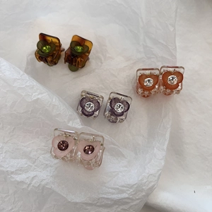 Détail de mini pinces à cheveux florales avec pétales en acrylique et strass brillants