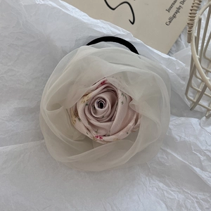 Detail of pink floral fabric hair claw with white organza trim and elastic band