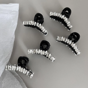 Cinq pinces à cheveux noires serties de strass sur fond gris pour un style chic