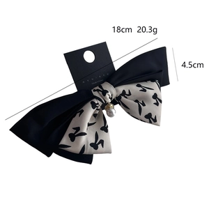 Elegant black and beige rabbit print bow hair clip with a pearl pendant accent