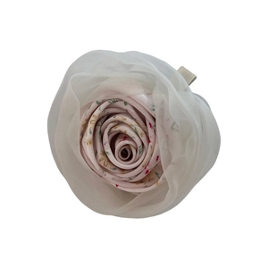 Detailed macro view of handmade fabric rose hair claw clip with pink floral organza petals