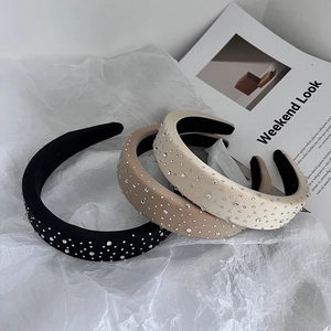 Close-up of thick sponge headbands with sparkling rhinestones in three neutral colors