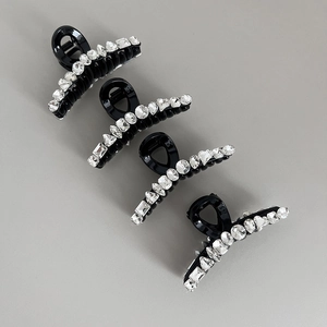 Vue détaillée de quatre pinces à cheveux noires avec divers motifs en strass brillants