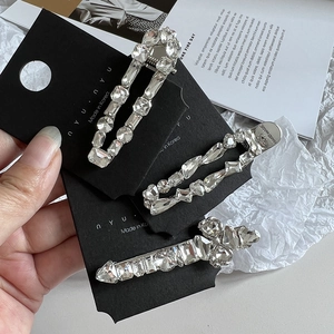 Détail de trois barrettes à cheveux en strass étincelants sur une carte noire