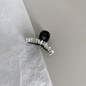 Vue détaillée d'une pince à cheveux noire avec strass géométriques et cristaux incrustés