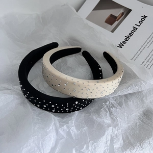 Detail of padded black and beige velvet headbands featuring intricate crystal rhinestones