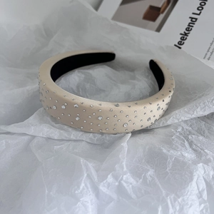 Detail of padded champagne satin headband with sparkling rhinestones and Weekend Look card