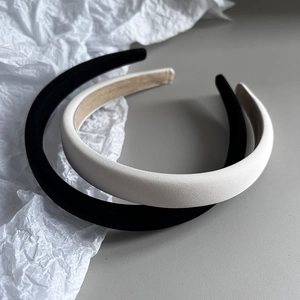 Detail view of two fabric headbands in black and white with non-slip beige lining