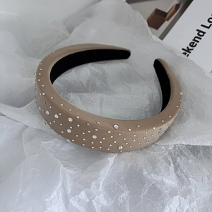 Detail of camel sponge headband with sparkling rhinestones on a textured fabric