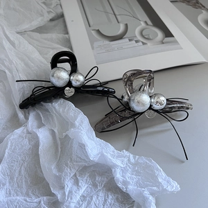 Macro view of black and translucent grey hair clips with bow and silver bead detail