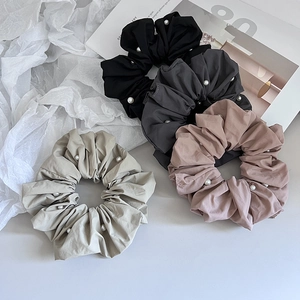 Λεπτομερής όψη τεσσάρων κομψών scrunchies με πέρλες σε μαύρο, γκρι, ροζ και μπεζ χρώμα