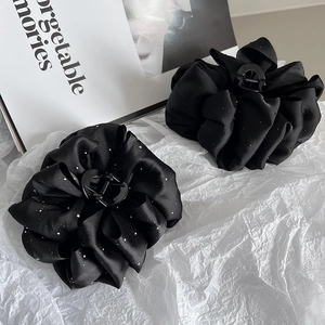 Close-up of black cloud bubble hair claw clip with sequins and ruffle floral design