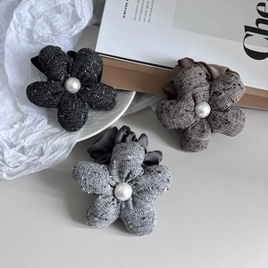 Detailed macro of tweed fabric flower hair ties with elegant pearl center accents