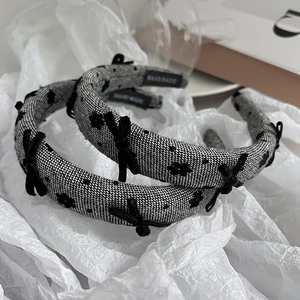 Detailed close-up of handmade woven bow headbands with velvet floral accents