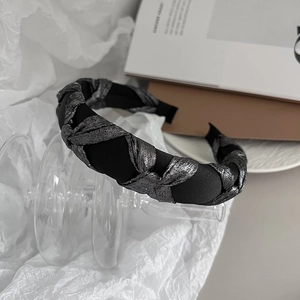 Close-up of twisted black fabric and silver metallic thread on wide sponge headband