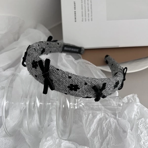 Detail showing tweed texture and velvet bow on a stylish handmade headband design