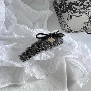Detail der Tweed-Haarklammer mit schwarzer Schleife und Goldanhänger im Vintage-Stil
