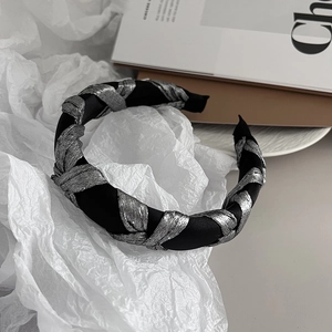 Close-up of a sponge padded headband with silver braided texture over black satin fabric
