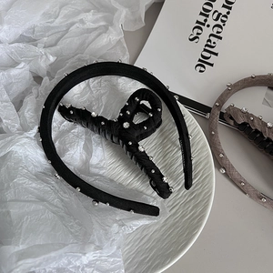 Close-up of black satin headband and clip set with silver beads and crystals
