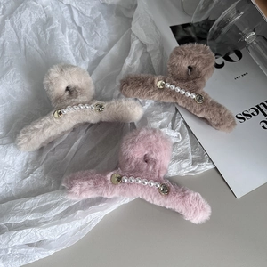 Détail de pinces à cheveux en peluche avec perles en blanc cassé, café et rose gris