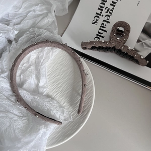 Brown fabric headband and claw clip set with silver beads on a minimalist background