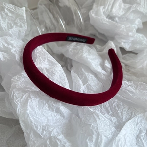 Close-up of burgundy velvet padded headband with a handmade label on the inner side