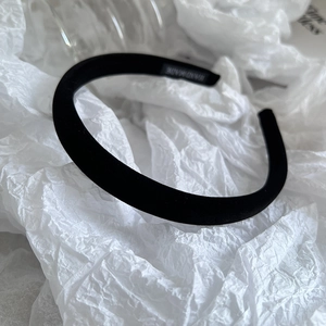 Detailed close-up of a handmade black velvet headband with a professional woven label