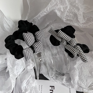 Détail de chouchous avec nœuds à carreaux noirs et blancs sur un fond blanc élégant