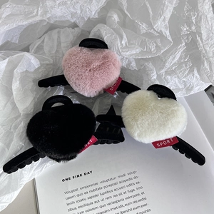 Trois pinces à cheveux coeur en peluche rose, noir et blanc avec détail de logo sport