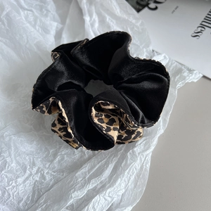 Détail du chouchou en velours léopard montrant la texture et le mélange de matériaux