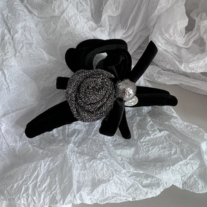 Detail of elegant black velvet hair claw with silver rose flower and metal bead