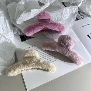 Dettaglio di fermagli per capelli in peluche viola, rosa e beige per acconciature invernali