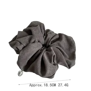 Elegant oversized dark grey fabric scrunchie with silver metal tag, 18.5cm diameter