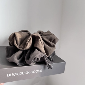 Elegant oversized suede fabric scrunchies in brown and grey with metal charm
